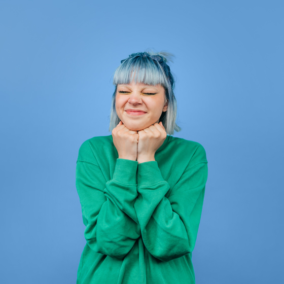 teen girl with blue hair feeling excited