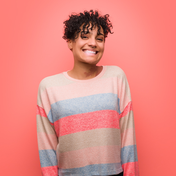 Happy, high school teen smiling with natural hair and a nose ring