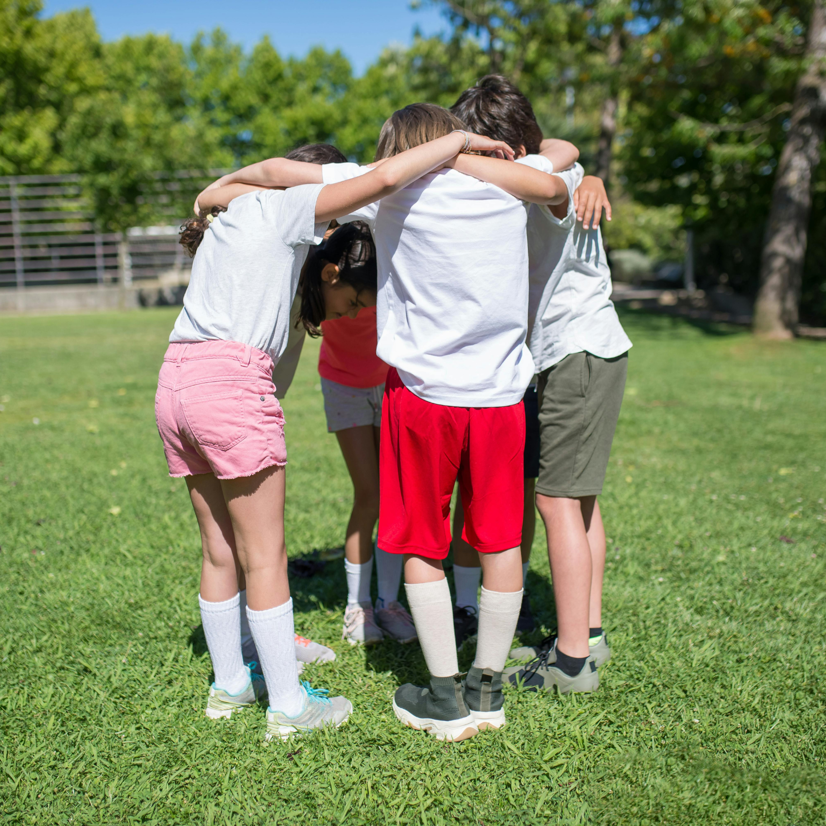 A group of young people with their arms around each other in a circle