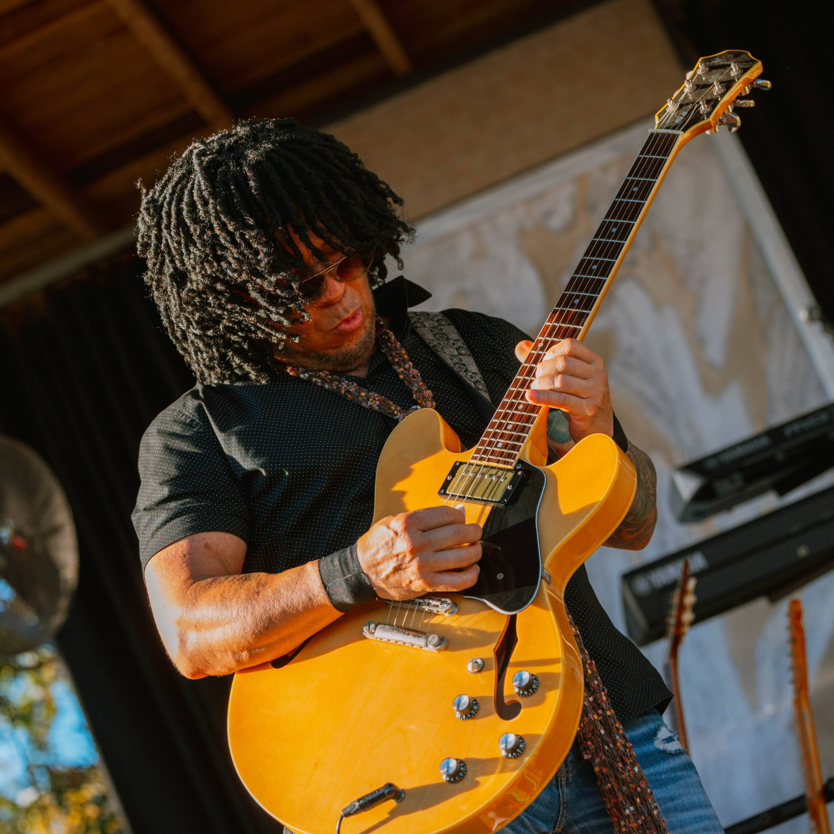 A Black male musician playing the guitar on stage at Oyster Fest